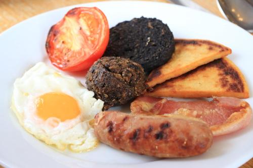 a plate of breakfast food with eggs sausage and toast at Gairloch Hotel 'A Bespoke Hotel' in Gairloch