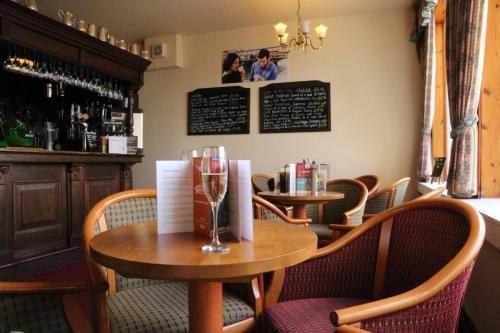 a dining room with two tables and chairs and a bar at Gairloch Hotel 'A Bespoke Hotel' in Gairloch