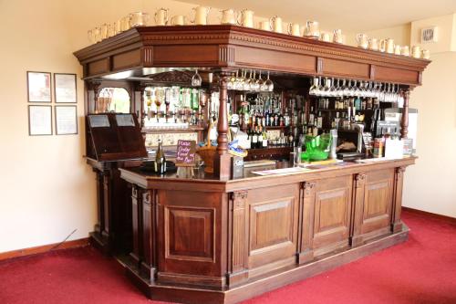 a large wooden bar in a room at Gairloch Hotel 'A Bespoke Hotel' in Gairloch