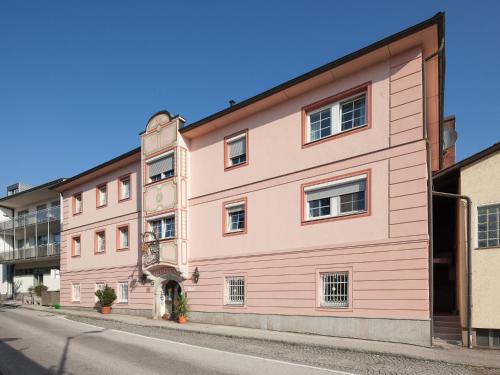 a pink building on the side of a street at Hotel Schlair in Kremsmünster