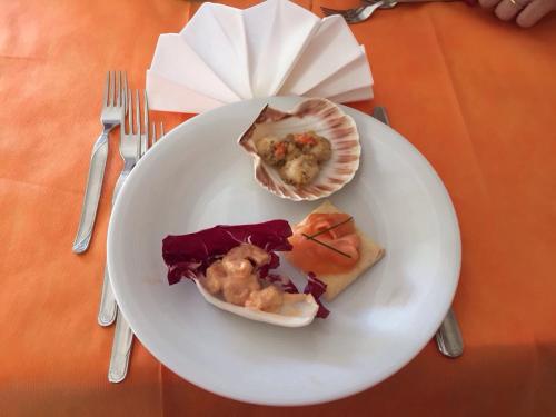 a white plate with some food on a table at Hotel Madrid in Riccione