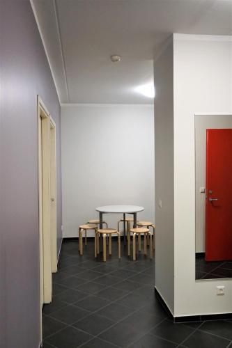 a room with a table and chairs and a red door at Downtown Hostel in Tartu