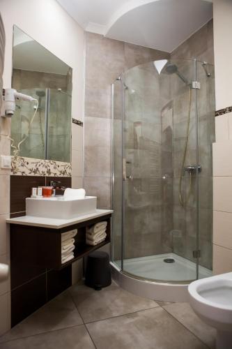 a bathroom with a sink and a shower at Villa Aronia pokoje z aneksem kuchennym , parking bezpłatny in Ustka