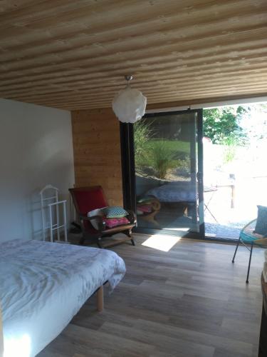 a bedroom with a bed and a large sliding glass door at Le chalet du Lac in Doussard