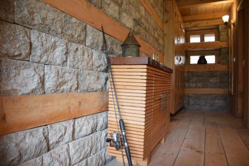 a room with a stone wall and a wooden door at Kudrat - A Boutique Homestay- Tirthan Valley in Banjār
