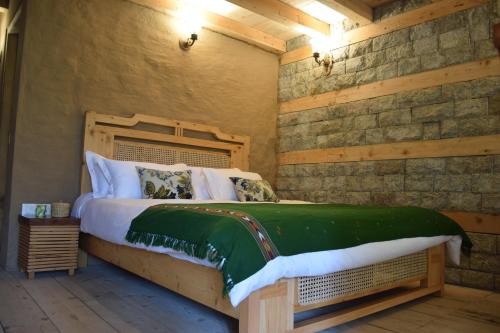 a bedroom with a bed in a wooden wall at Kudrat - A Boutique Homestay- Tirthan Valley in Banjār