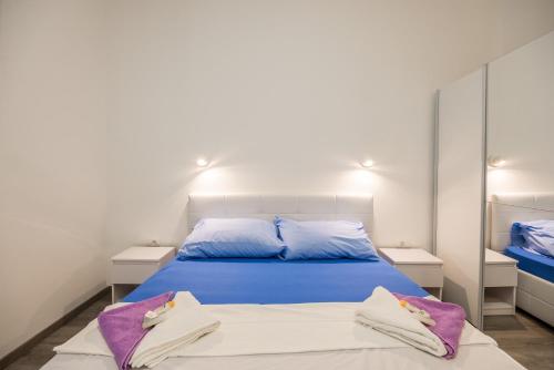 Schlafzimmer mit einem Bett mit blauer Bettwäsche und lila Kissen in der Unterkunft Downtown Rijeka in Rijeka