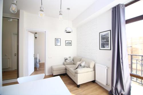 - un salon blanc avec un canapé et une fenêtre dans l'établissement Avlabari Apartment, à Tbilissi