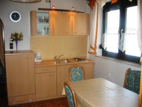uma cozinha com um lavatório e uma mesa com uma mesa; em Ferienwohnungen Haus Waltraud em Steinwiesen