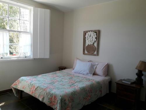 een slaapkamer met een bed en 2 ramen bij Pousada Cantagalo Bichinho MG in Bichinho