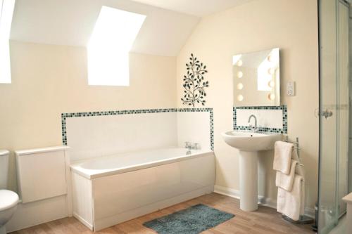 Un baño blanco con bañera y lavabo. en Bryn Melyn Farm Cottages, en Bala