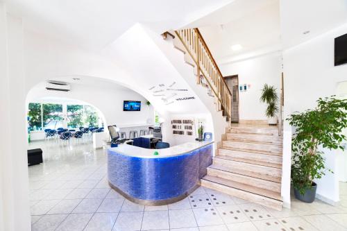 un hall de bureau avec un comptoir bleu et blanc dans l'établissement Mantovani Hotel Murano & Mariù, à Rimini