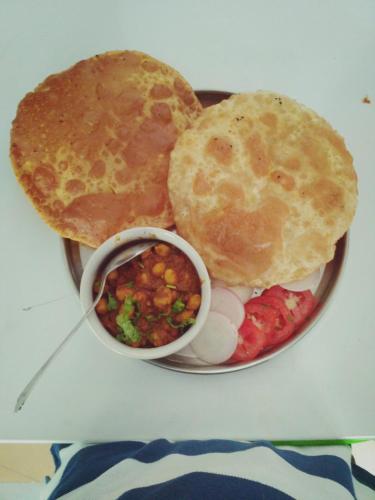 ein Teller mit Essen mit einem Sandwich und Pfannkuchen in der Unterkunft Hotel Ramnivas in Udaipur