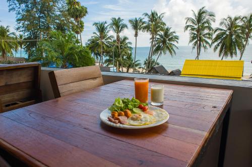 a plate of food on a table with a view of the ocean at Baantalay Thungwualaen in Pathiu
