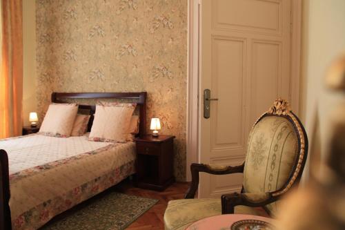1 dormitorio con 1 cama y 1 silla en Casa Blanca, en Sibiu