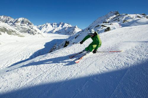 a man is skiing down a snow covered mountain at Badehotel Salina Maris – Wellness & Vintage in Mörel