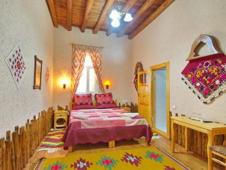 1 dormitorio con 1 cama grande en una habitación en Qosha Darvoza, en Khiva