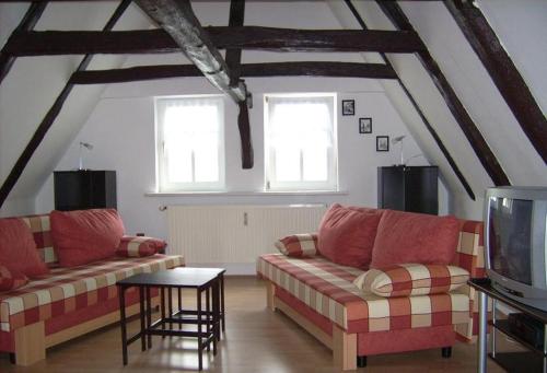 a living room with two couches and a tv at Ferienwohnungen "Altes Bachhaus" in Eisenach