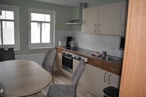 a kitchen with a table and a sink and a table and chairs at Ferienwohnungen "Altes Bachhaus" in Eisenach