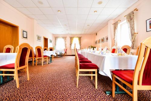 a dining room with white tables and chairs at Hotel Zum Stern Spreewald in Werben