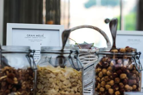 three glass jars filled with different types of nuts at Villa Agrippina Gran Meliá – The Leading Hotels of the World in Rome