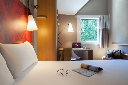um quarto com uma cama com um par de óculos em ibis Velizy Jouy-En-Josas em Jouy-en-Josas