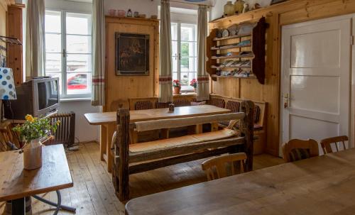 a dining room with a table and chairs and windows at Fit und Fun Sportherberge in Kötschach