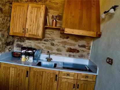 a kitchen with a sink and wooden cabinets at Arqueixal Ecoagroturismo in Albá