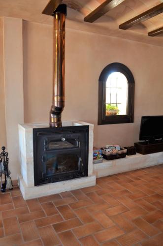 a fireplace in a living room with a stove at Ca Na Marina in Cala Llombards