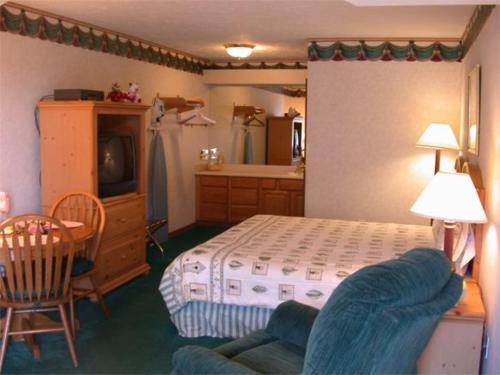 a bedroom with a bed and a table with a chair at Townhouse Inn & Suites Omaha in Omaha
