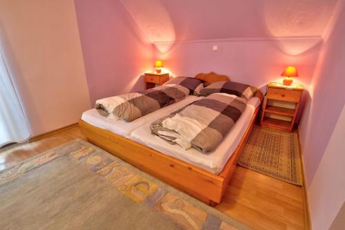 a bedroom with a large bed in a room with two lamps at Country House Slemenšek in Vojnik