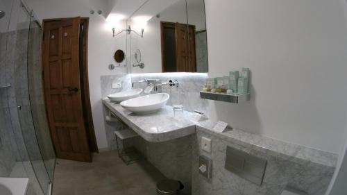 a bathroom with two sinks and a mirror at Parador de Santiago - Hostal Reis Catolicos in Santiago de Compostela