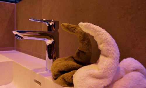 a stuffed animal sitting on a sink next to a faucet at Chalet Tschallener in Ried im Oberinntal