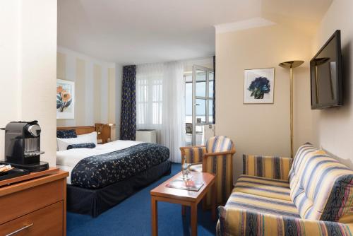 メルゼブルクにあるラディソン ブルー ホテル ハレ - メルセブルクのベッドとソファ付きのホテルルーム