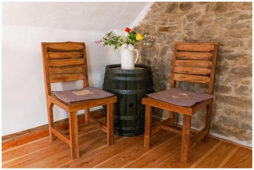 two chairs and a vase with flowers on top of a barrel at Osada Havranů in Hnanice