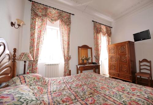 a bedroom with a bed and a dresser and a window at Hotel Aviz in Figueira da Foz