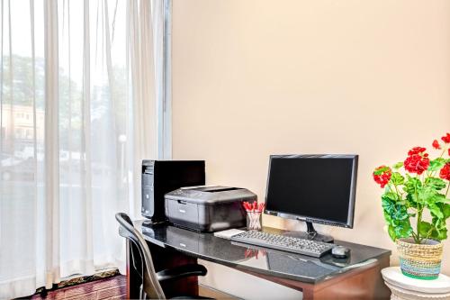 a desk with a computer and a printer on it at Ramada by Wyndham Rockaway in Rockaway