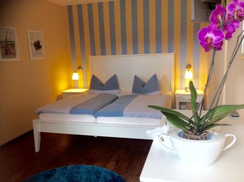 a bedroom with a bed with blue pillows and a plant at Ferienwohnung "Alter Gutshof" Hühnergott in Ostseebad Sellin