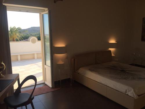 a bedroom with a bed and a door to a balcony at Borgo Ginuga in Centuripe