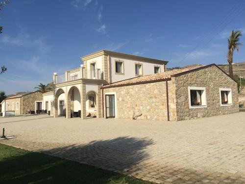 a large stone building with a palm tree behind it at Borgo Ginuga in Centuripe