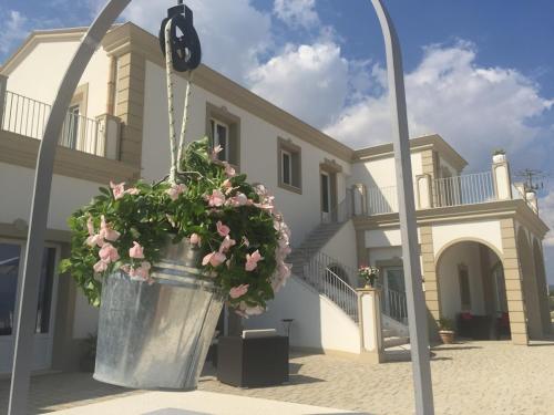 a large pot of flowers in front of a house at Borgo Ginuga in Centuripe