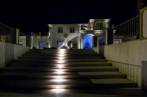 a staircase leading to a white building at night at Borgo Ginuga in Centuripe