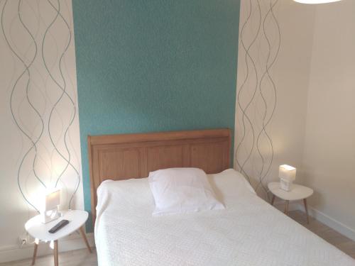een slaapkamer met een bed met 2 nachtkastjes en 2 lampen bij auberge du breuil vieux moulin in Le Creusot