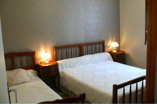 - une chambre avec 2 lits et 2 lampes sur les tables dans l'établissement Maison Bord Du Lac, à Marcillac-la-Croisille