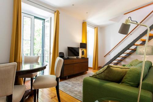 a living room with a green couch and a table at Santos River View Terrace Duplex in Lisbon