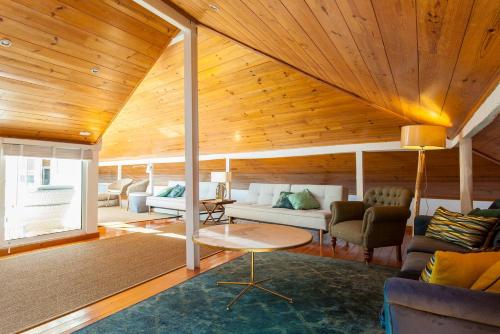 a living room with wooden ceilings and a couch and chairs at Santos River View Terrace Duplex in Lisbon
