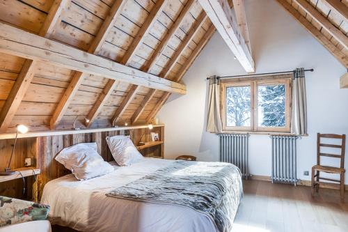 a bedroom with a large bed in a room with wooden ceilings at Chalet Hermine in Megève