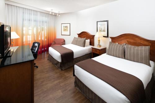 a hotel room with two beds and a flat screen tv at Red Lion Hotel Boise Downtowner in Boise