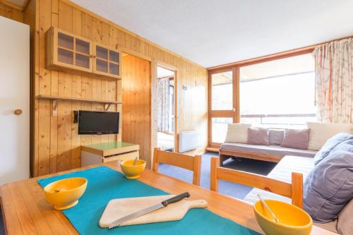 - un salon avec une table et des bols dans l'établissement Résidence Nova, à Arc 1800