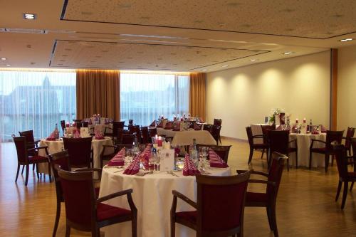 a dining room with tables and chairs and tablesearcher at Hotel Rose in Bretzfeld
